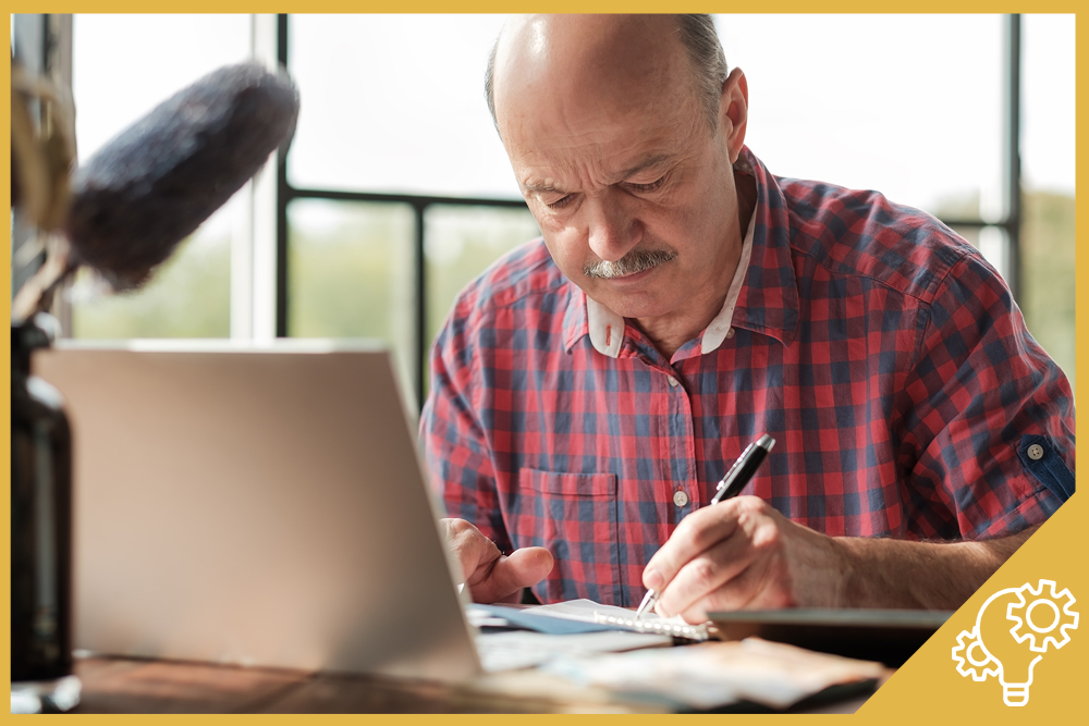 Hombre sénior concentrado en la preparación de un proyecto de emprendimiento que ha visto en una clase de Canal Sénior